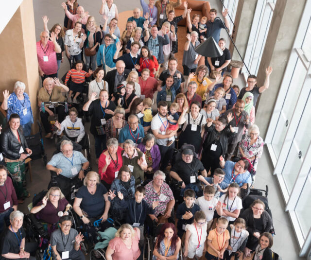 Crowd of people in hallway looking up at camera